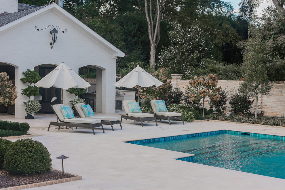 Diseño de piscina natural mediterránea grande rectangular en patio trasero con suelo de baldosas