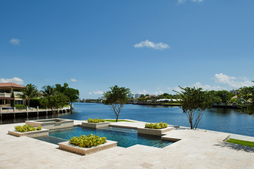 Großer Klassischer Pool hinter dem Haus in rechteckiger Form mit Natursteinplatten in Miami
