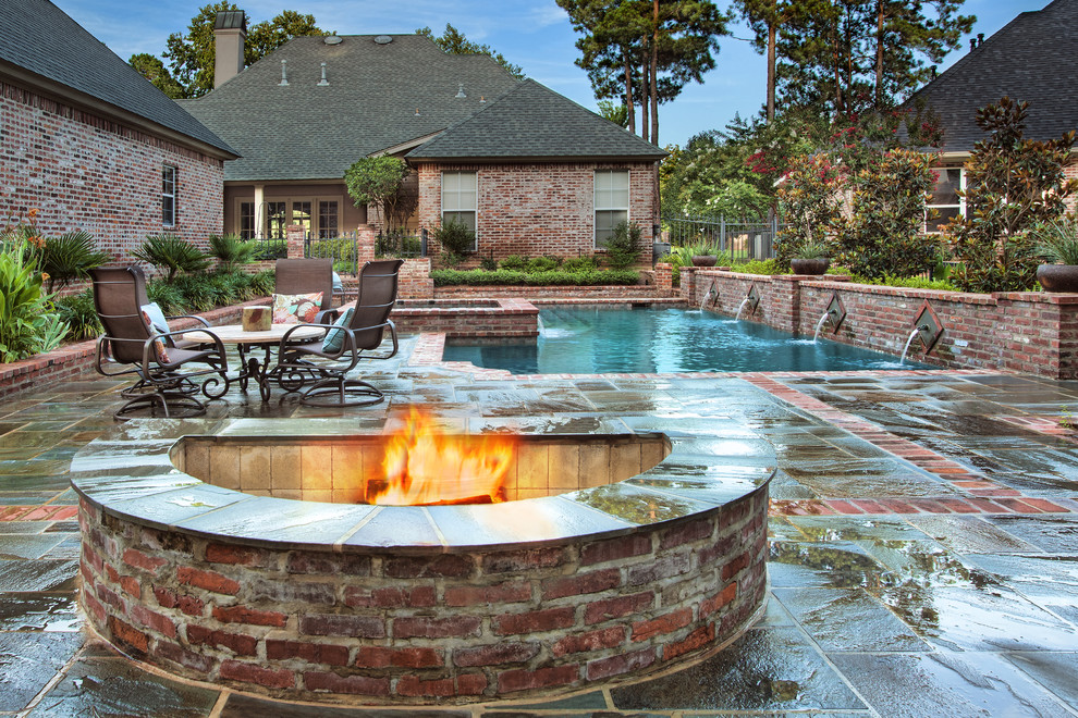 Large classic courtyard custom shaped lengths hot tub in New Orleans with natural stone paving.