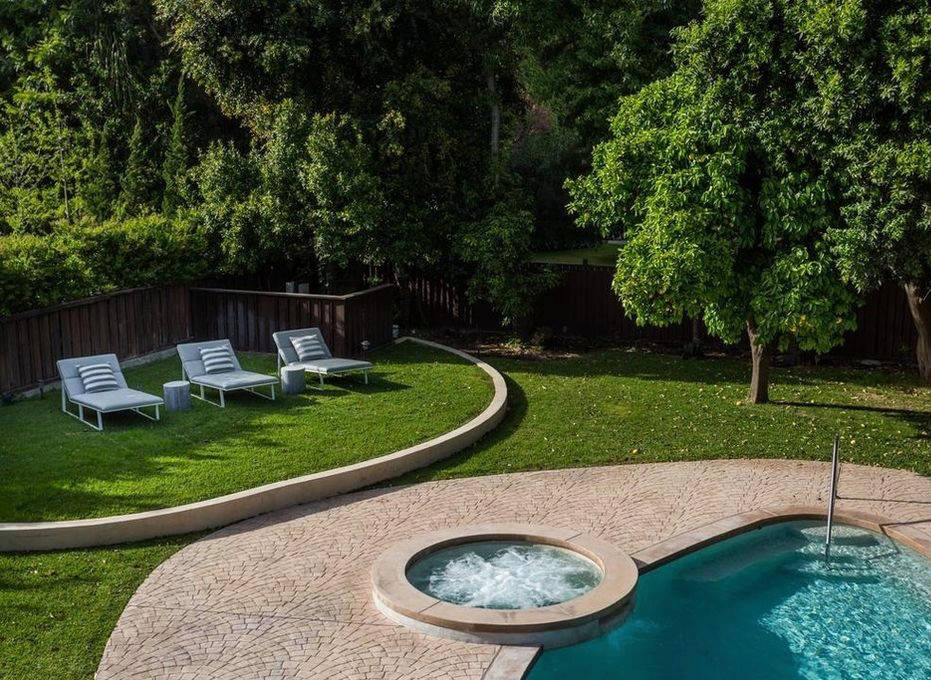 Ejemplo de piscinas y jacuzzis clásicos renovados grandes a medida en patio trasero con suelo de hormigón estampado