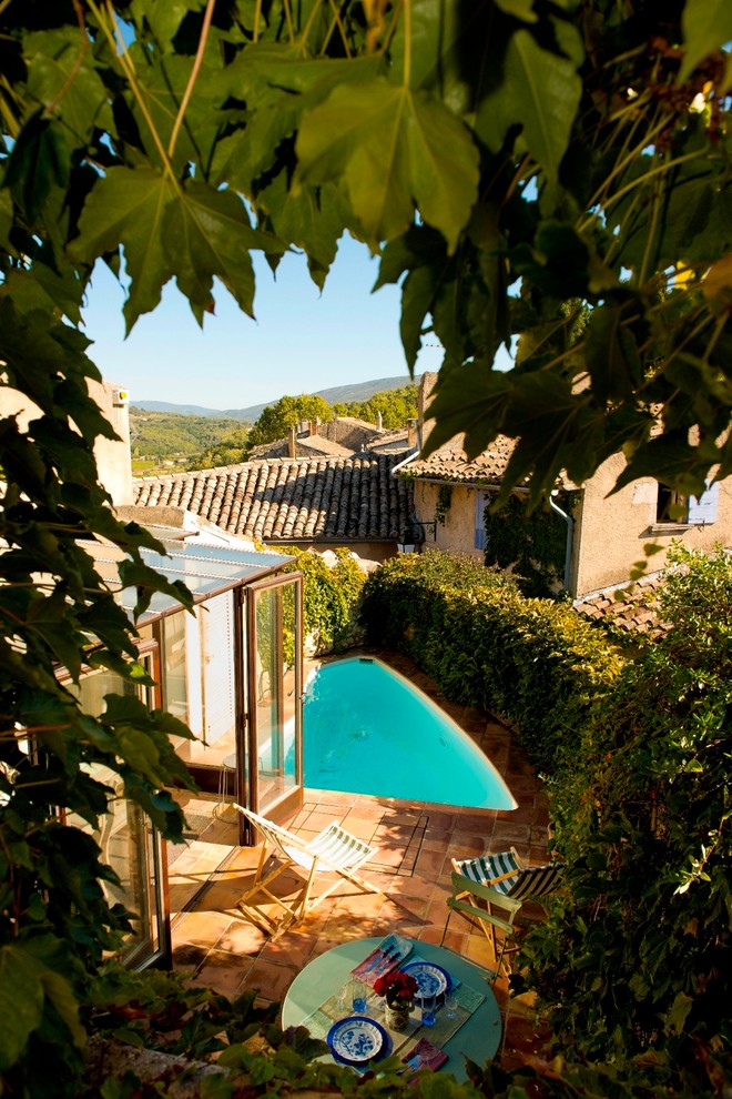 На фото: маленький бассейн произвольной формы на внутреннем дворе в средиземноморском стиле с покрытием из плитки для на участке и в саду