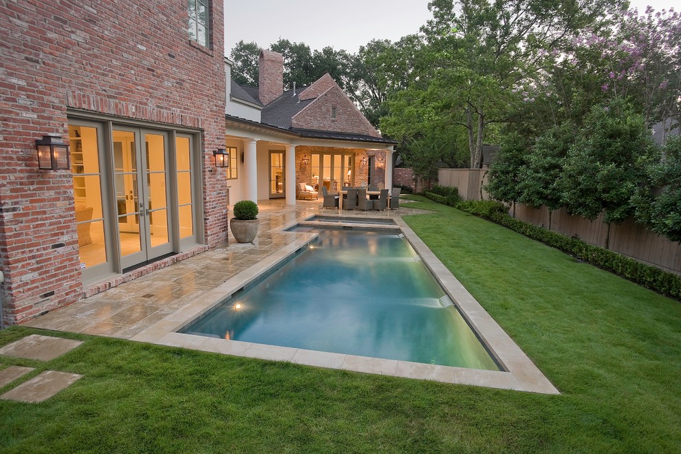 Ejemplo de piscinas y jacuzzis alargados tradicionales de tamaño medio en forma de L en patio trasero con adoquines de hormigón