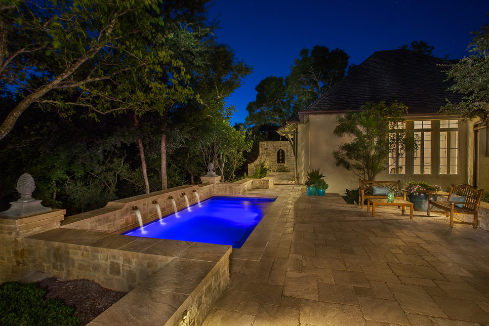 Foto de piscina con fuente alargada clásica de tamaño medio rectangular en patio trasero con adoquines de piedra natural