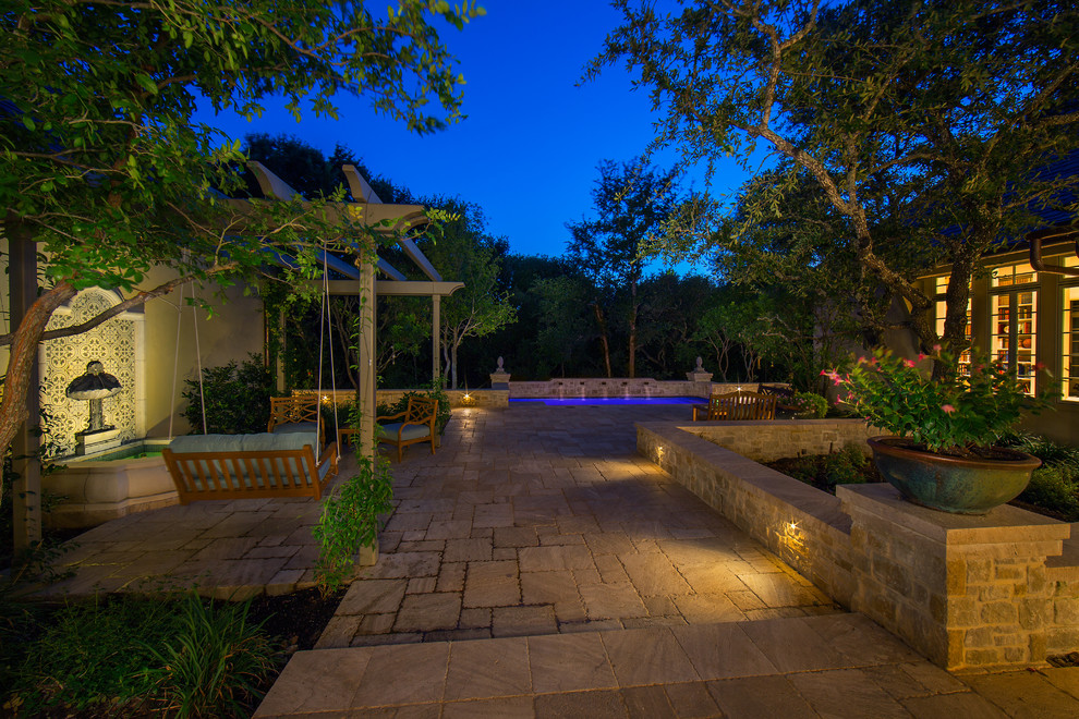 Foto de piscina con fuente alargada tradicional de tamaño medio rectangular en patio trasero con adoquines de piedra natural