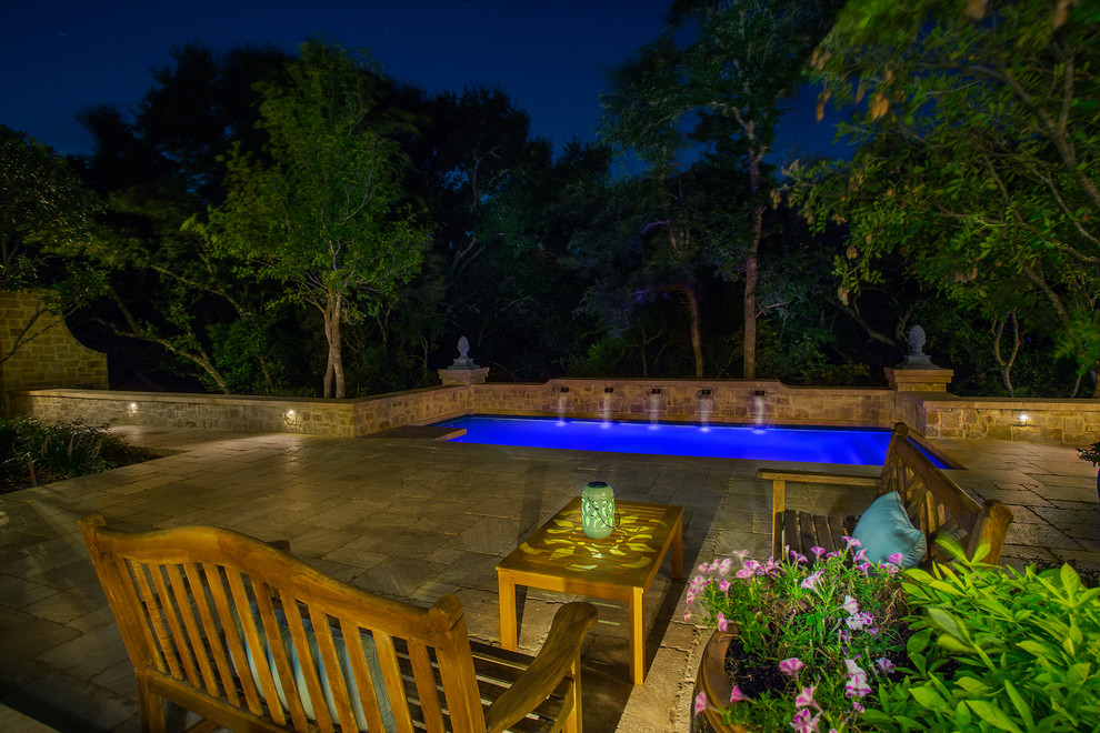 Imagen de piscina con fuente alargada tradicional de tamaño medio rectangular en patio trasero con adoquines de piedra natural
