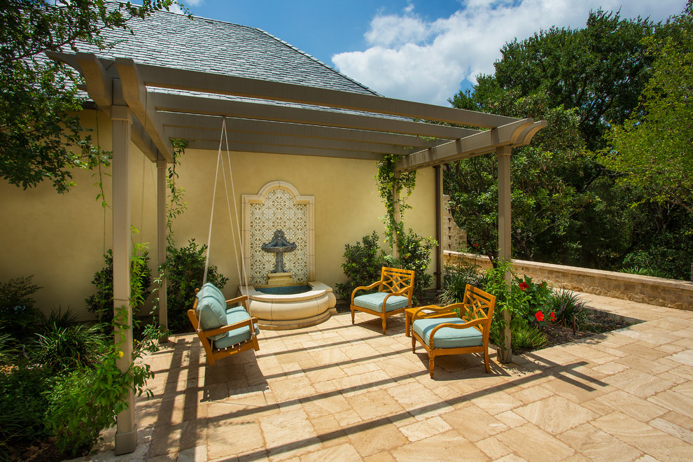 Modelo de piscina con fuente alargada tradicional de tamaño medio rectangular en patio trasero con adoquines de piedra natural