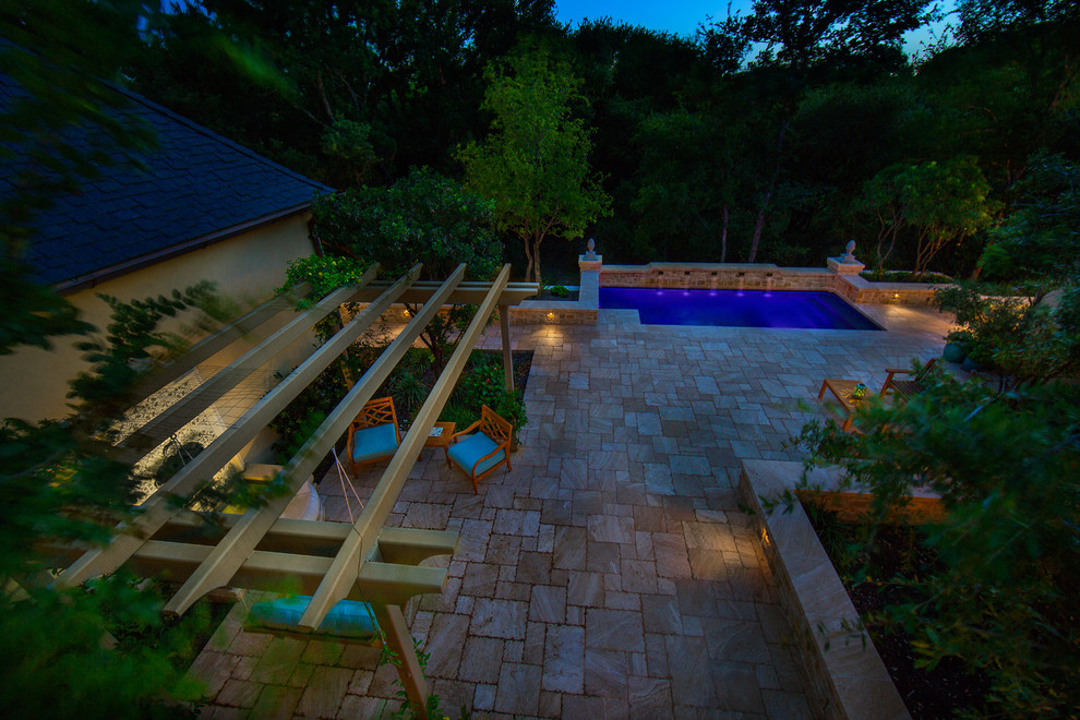 Photo of a medium sized classic back rectangular lengths swimming pool in Austin with a water feature and natural stone paving.