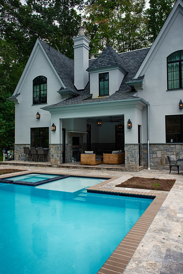 Ispirazione per una grande piscina naturale classica personalizzata dietro casa con una vasca idromassaggio e pavimentazioni in pietra naturale