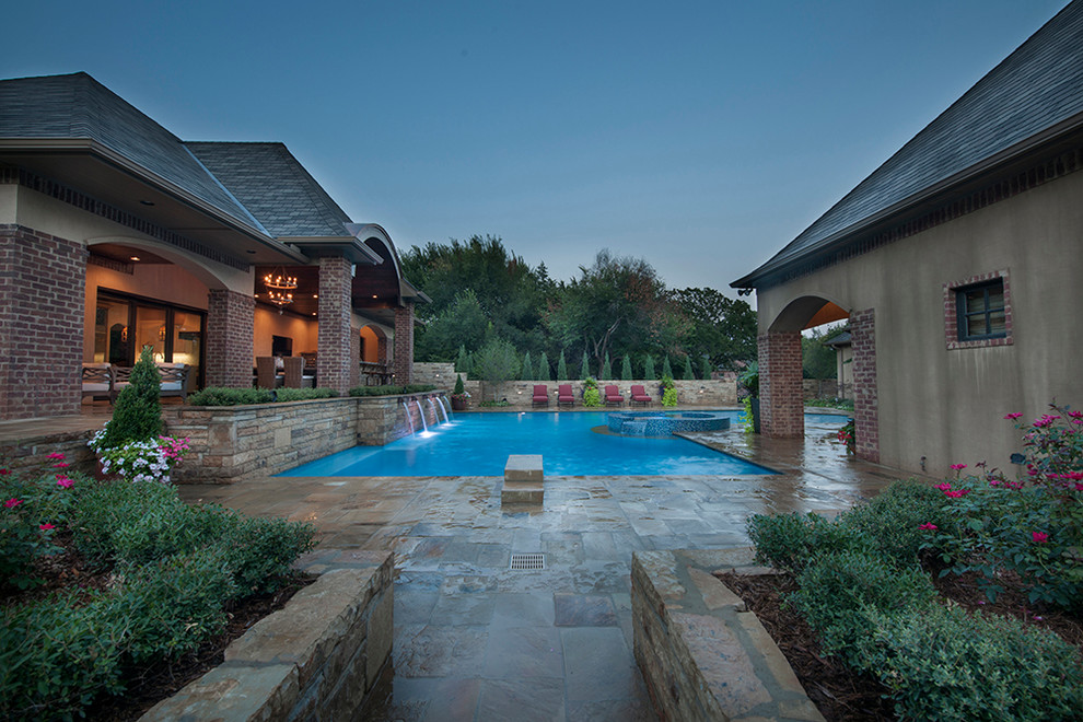 Cette image montre une grande piscine arrière minimaliste en L avec des pavés en pierre naturelle.