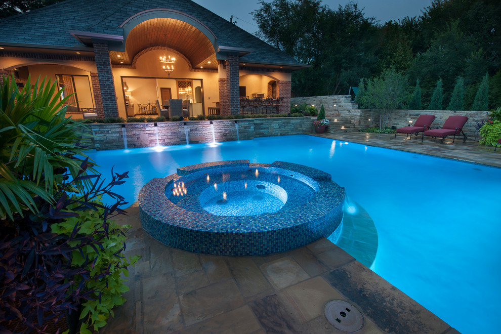 Ejemplo de piscinas y jacuzzis alargados modernos grandes en forma de L en patio trasero con adoquines de piedra natural