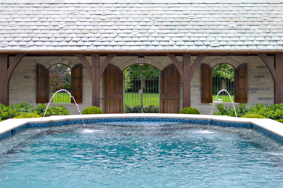 Photo of a traditional courtyard swimming pool in Dallas with a water feature.