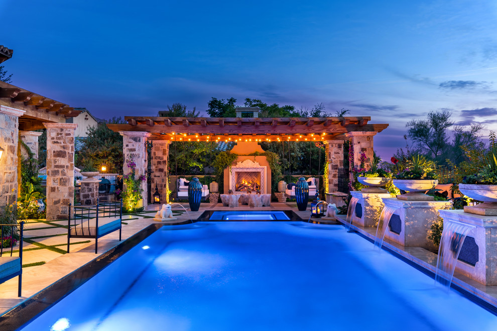 Ispirazione per un'ampia piscina a sfioro infinito mediterranea rettangolare dietro casa con una vasca idromassaggio e piastrelle