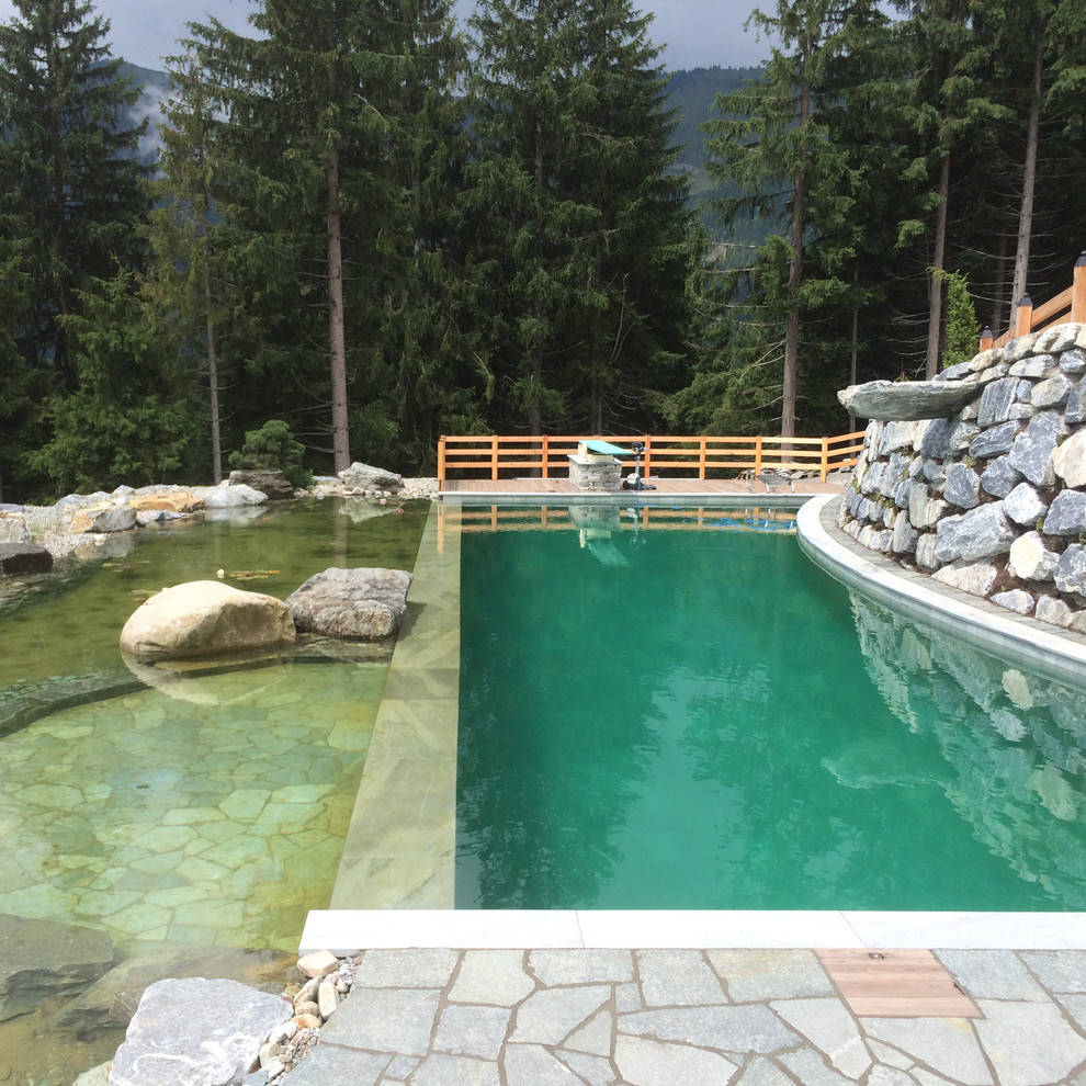 Immagine di una piscina naturale rustica rettangolare con pavimentazioni in pietra naturale