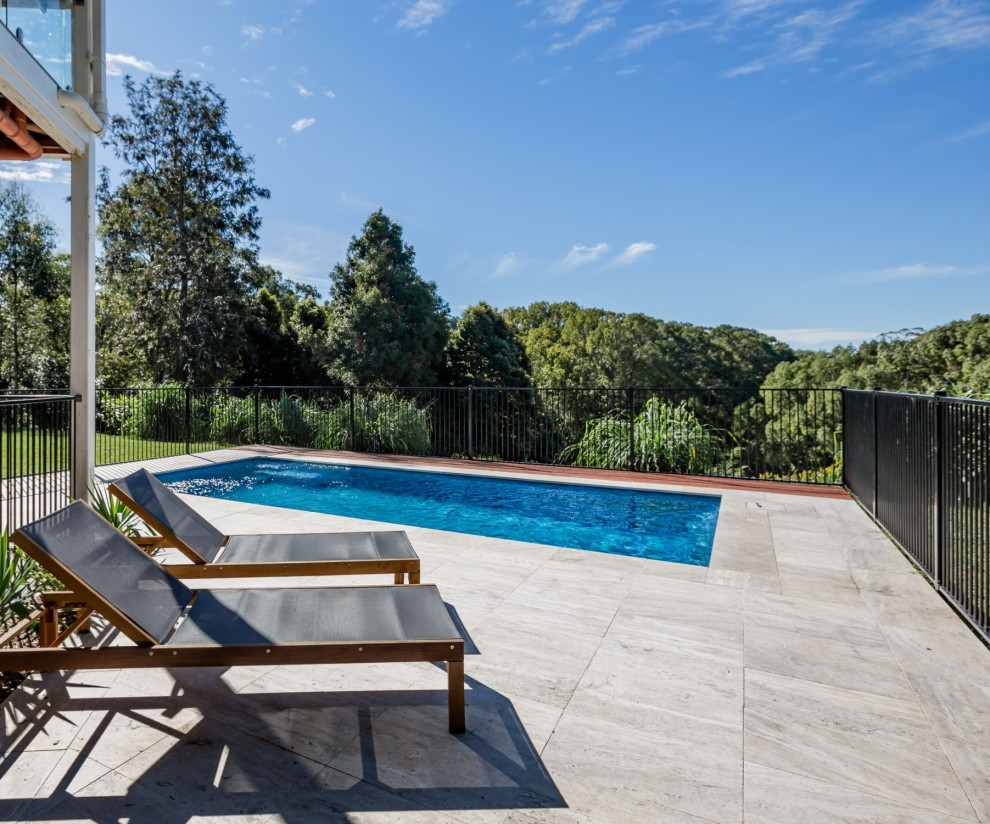 Medium sized coastal back rectangular above ground swimming pool in Gold Coast - Tweed with natural stone paving.