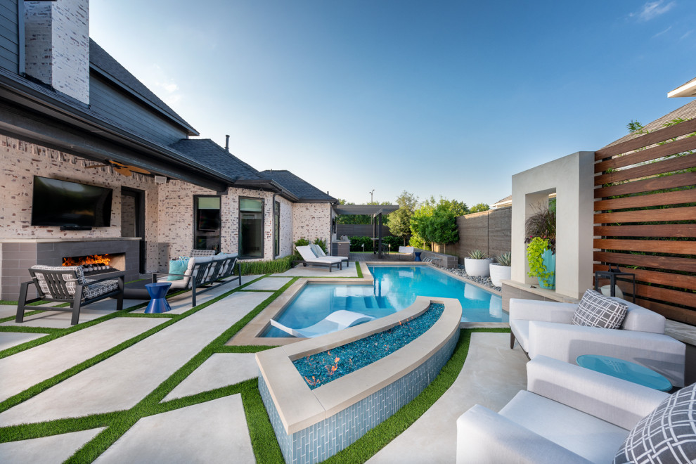 На фото: угловой бассейн среднего размера на заднем дворе в стиле модернизм с покрытием из бетонных плит с