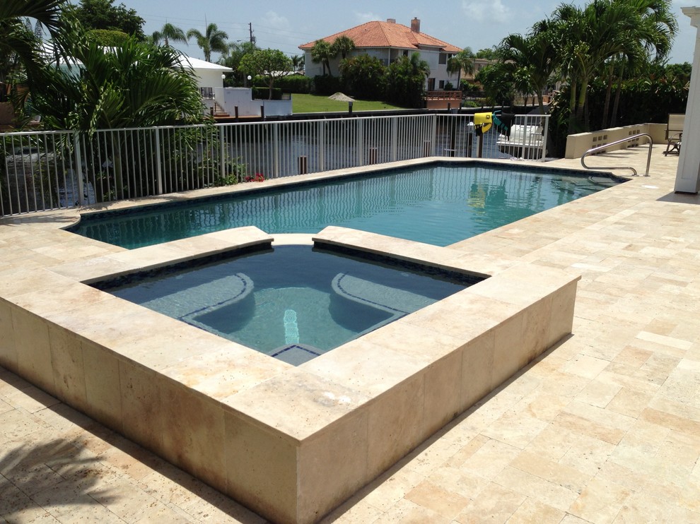 Diseño de piscinas y jacuzzis alargados clásicos renovados grandes rectangulares en patio trasero con suelo de baldosas