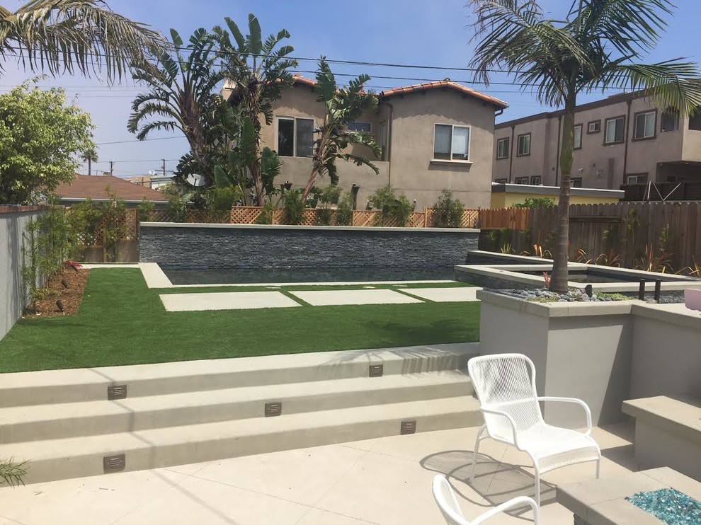 Foto de piscinas y jacuzzis naturales contemporáneos grandes rectangulares en patio trasero con losas de hormigón