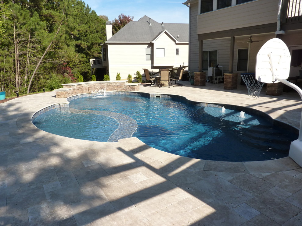 Photo of a large classic back custom shaped hot tub in Atlanta with stamped concrete.