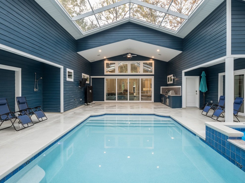 Aménagement d'une piscine classique de taille moyenne et rectangle avec une dalle de béton.