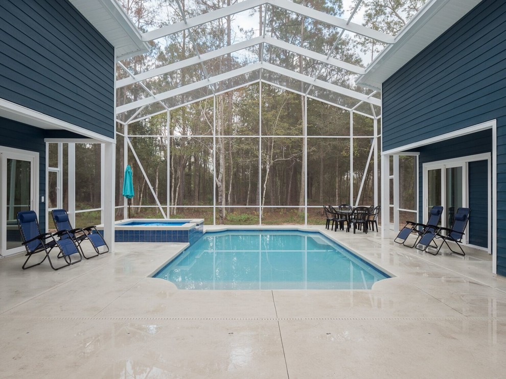 Immagine di una piscina coperta monocorsia classica rettangolare di medie dimensioni con lastre di cemento