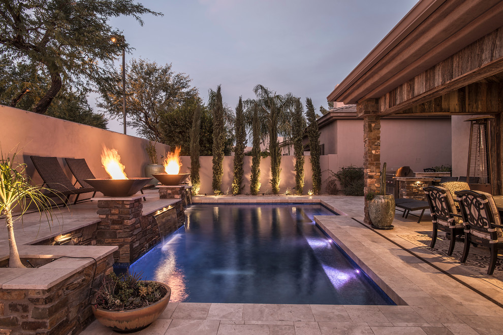 Ejemplo de piscina con fuente natural clásica renovada de tamaño medio en forma de L en patio trasero con adoquines de piedra natural