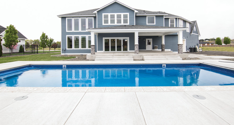 This is an example of a large traditional back rectangular lengths swimming pool in Other with concrete slabs.