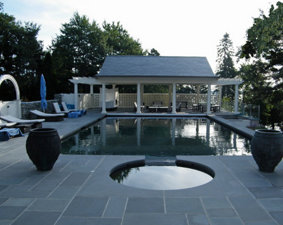 Modelo de casa de la piscina y piscina alargada de tamaño medio a medida en patio trasero con suelo de hormigón estampado