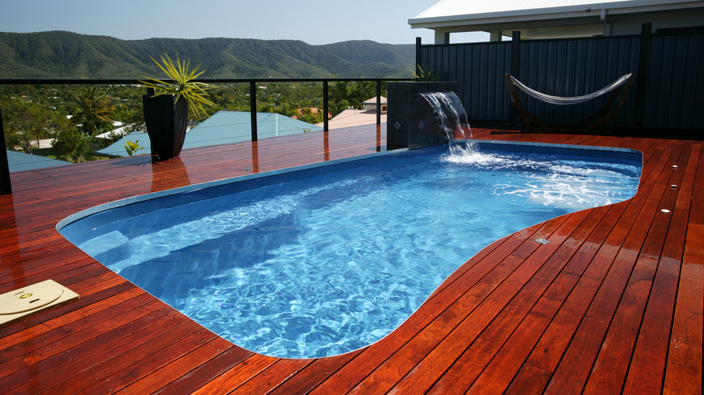 Aménagement d'une piscine sur toit hors-sol de taille moyenne et rectangle avec un point d'eau et une terrasse en bois.