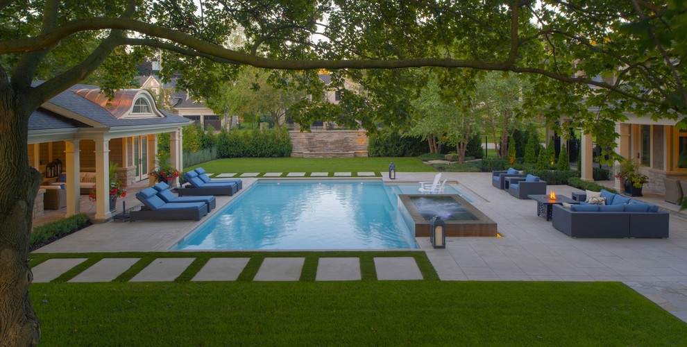 This is an example of a medium sized contemporary side rectangular lengths swimming pool in Toronto with a pool house and concrete slabs.
