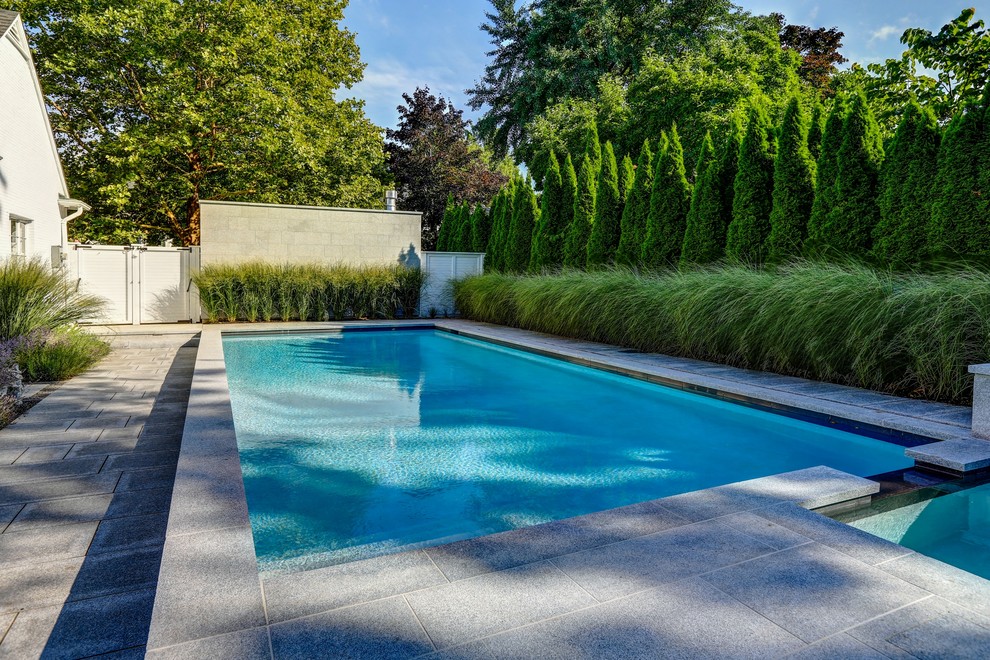 Mid-sized transitional backyard stone and rectangular hot tub photo in Toronto