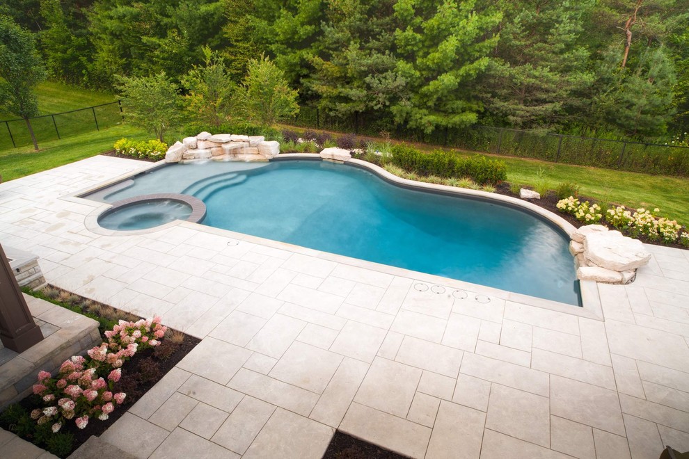 Foto di una grande piscina naturale minimal personalizzata dietro casa con fontane e cemento stampato