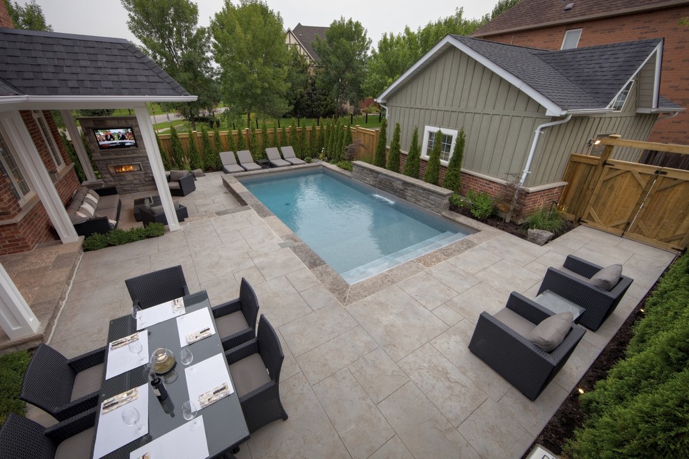 Ejemplo de piscina con fuente alargada contemporánea pequeña rectangular en patio trasero con suelo de hormigón estampado