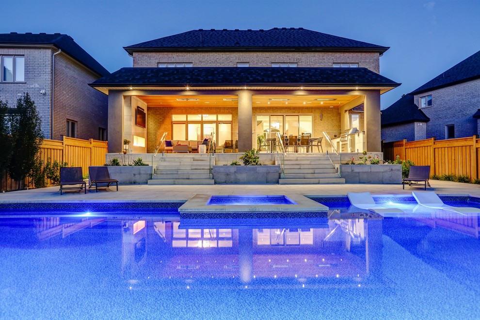Идея дизайна: прямоугольный бассейн среднего размера на заднем дворе в стиле неоклассика (современная классика) с домиком у бассейна и покрытием из каменной брусчатки