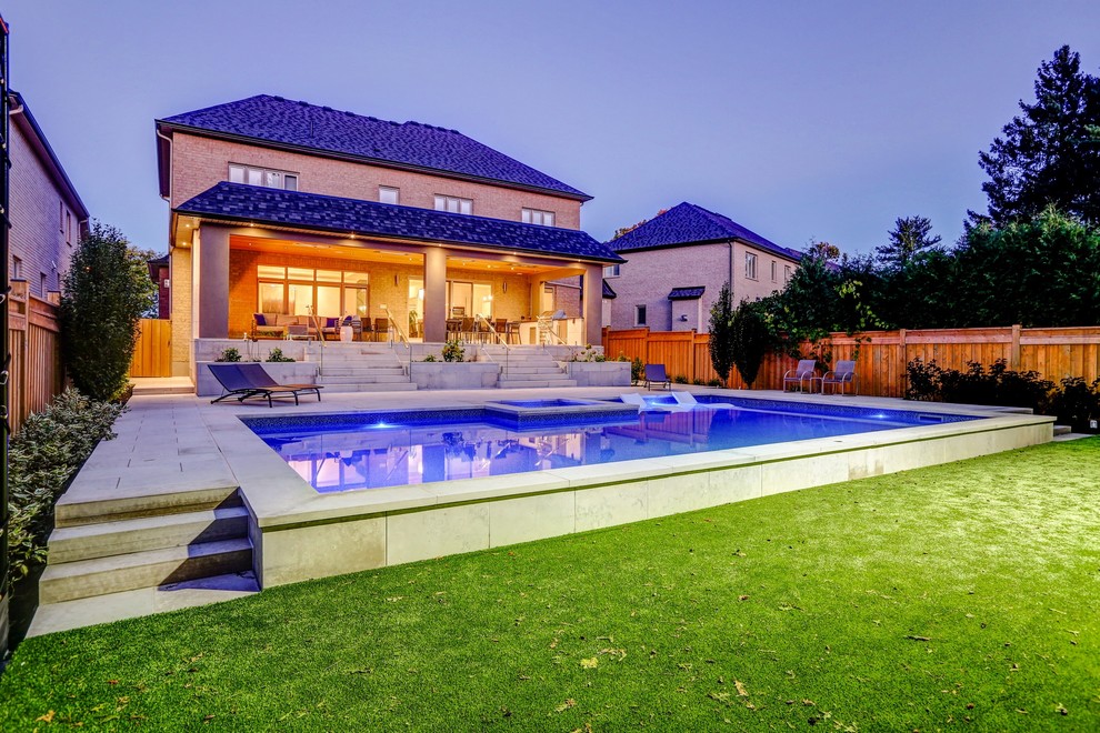 Ejemplo de casa de la piscina y piscina clásica renovada de tamaño medio rectangular en patio trasero con adoquines de piedra natural