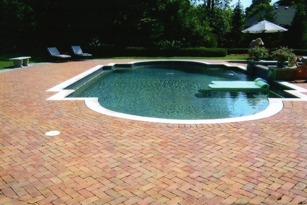 Diseño de piscinas y jacuzzis alargados actuales de tamaño medio a medida en patio trasero con adoquines de ladrillo