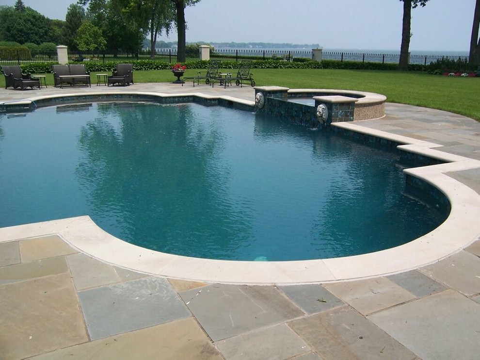 Immagine di una grande piscina monocorsia contemporanea personalizzata dietro casa con una vasca idromassaggio e pavimentazioni in pietra naturale