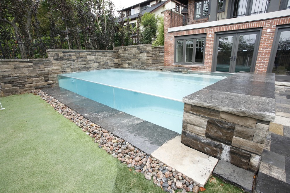 Inspiration pour une petite piscine à débordement et arrière design rectangle avec des pavés en pierre naturelle.
