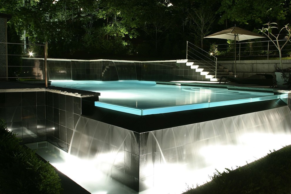 Источник вдохновения для домашнего уюта: прямоугольный бассейн-инфинити среднего размера на заднем дворе в современном стиле с джакузи и покрытием из каменной брусчатки