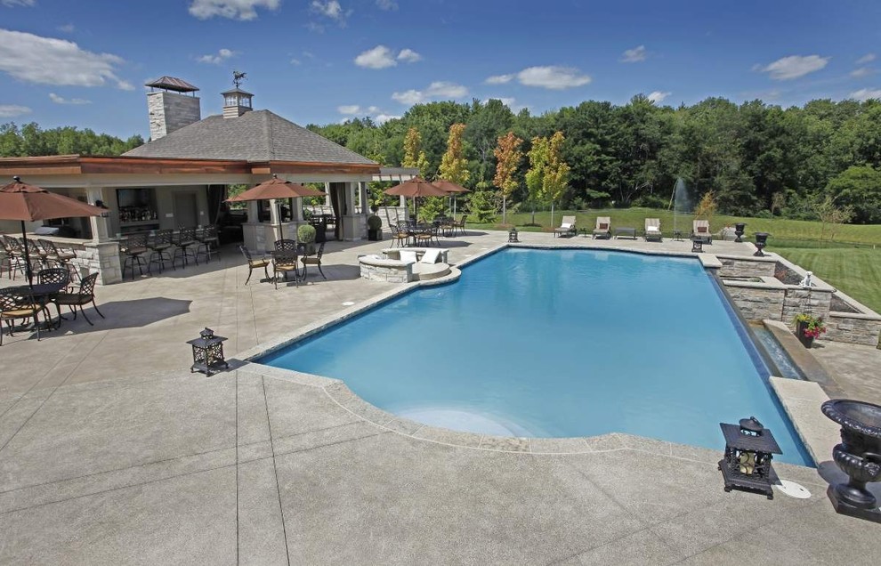 Modelo de casa de la piscina y piscina infinita actual grande rectangular en patio trasero con granito descompuesto