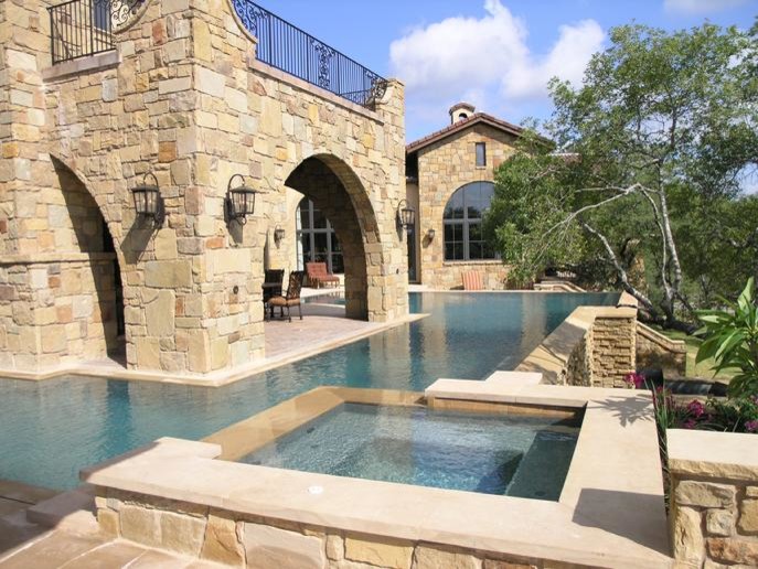 Пример оригинального дизайна: большой бассейн произвольной формы на заднем дворе в средиземноморском стиле с джакузи и покрытием из каменной брусчатки