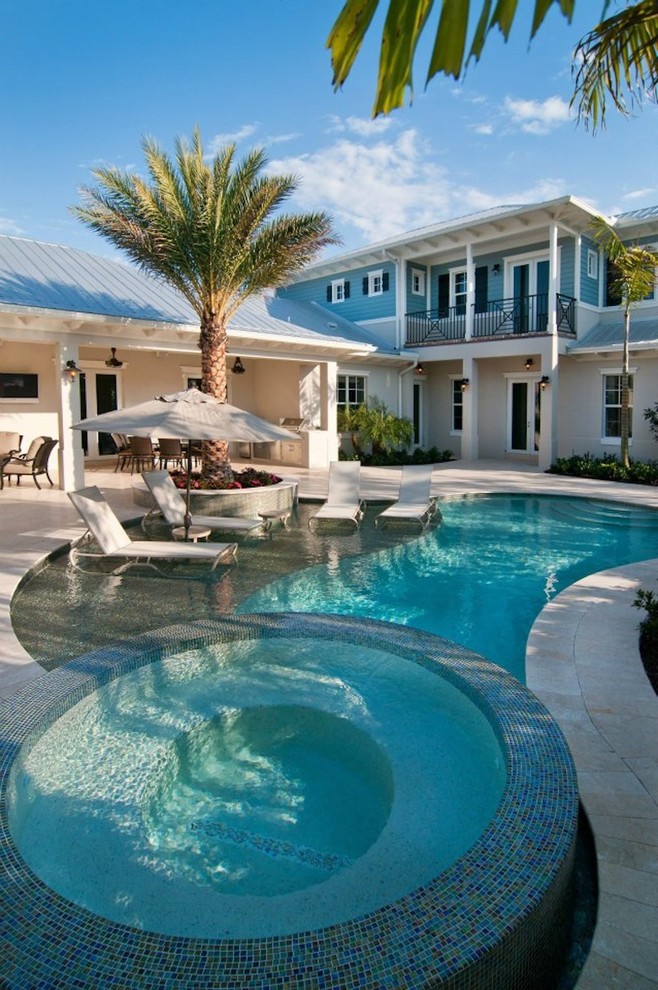 Foto di una piscina tropicale a "C" di medie dimensioni e davanti casa con pavimentazioni in mattoni