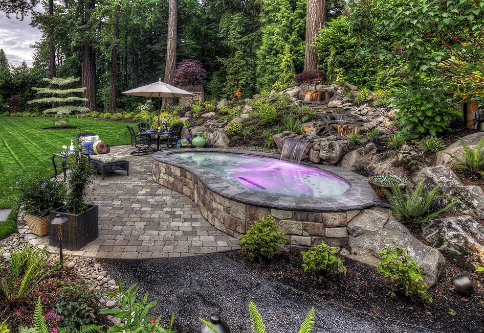 Example of a small transitional backyard stone and kidney-shaped aboveground pool fountain design in Orange County