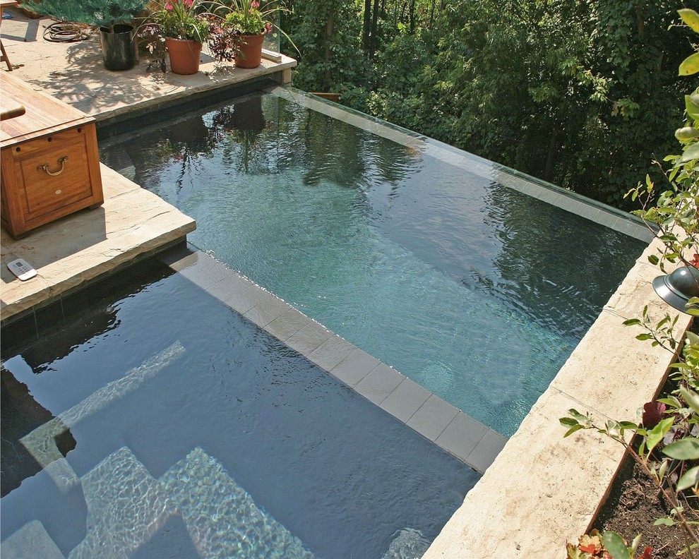 Imagen de piscinas y jacuzzis alargados actuales pequeños rectangulares en patio trasero con adoquines de piedra natural