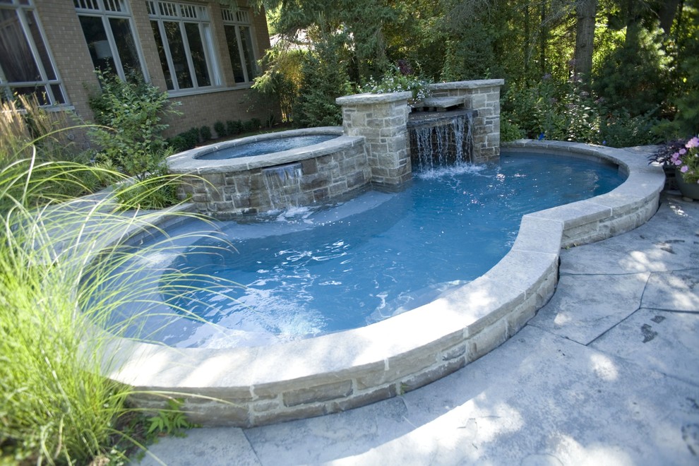 Foto de piscina con fuente actual pequeña a medida en patio trasero con adoquines de piedra natural