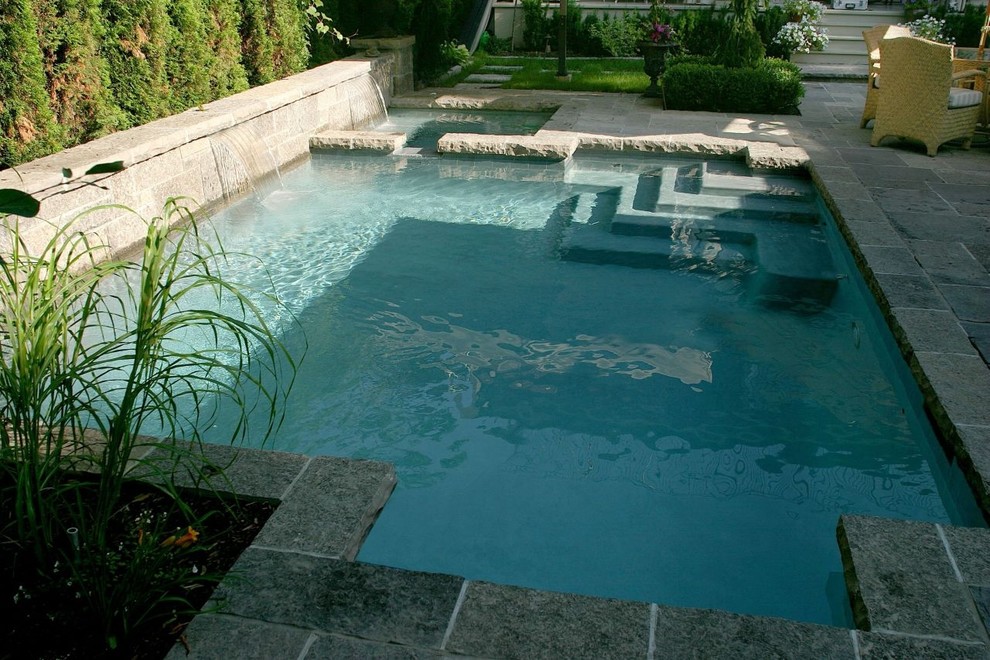 Diseño de piscinas y jacuzzis alargados actuales pequeños a medida en patio trasero con adoquines de piedra natural