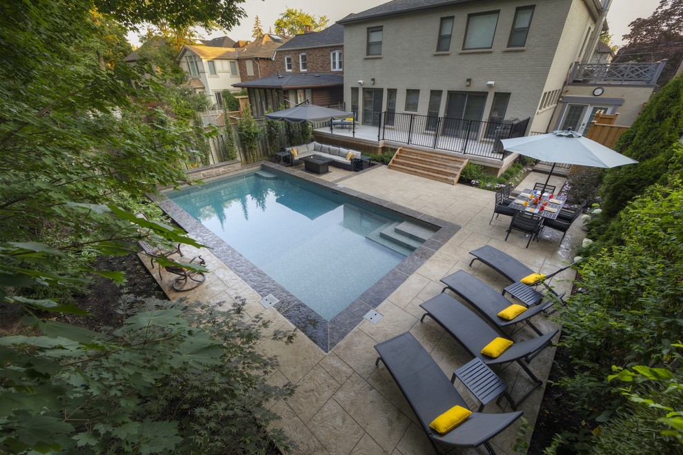 Imagen de piscina pequeña rectangular en patio trasero con suelo de hormigón estampado