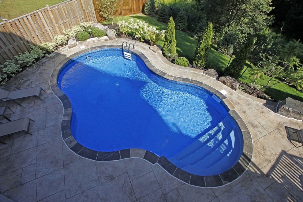 Small contemporary back swimming pool in Toronto with stamped concrete.