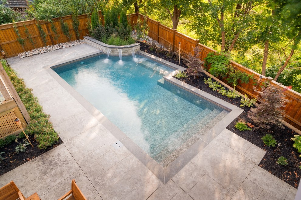Foto på en liten pool på baksidan av huset, med spabad och stämplad betong