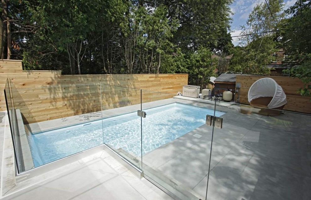 Пример оригинального дизайна: маленький прямоугольный бассейн на заднем дворе в современном стиле с покрытием из декоративного бетона для на участке и в саду