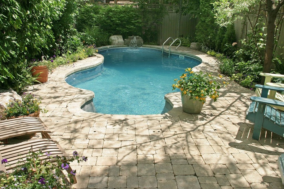Foto på en liten funkis pool på baksidan av huset, med en fontän och marksten i betong
